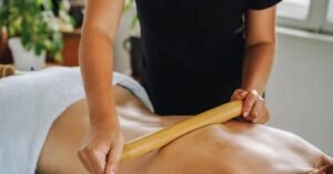 Terapeuta aplicando massagem com bastão em paciente deitado