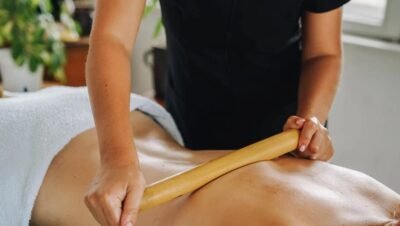 Terapeuta aplicando massagem com bastão em paciente deitado
